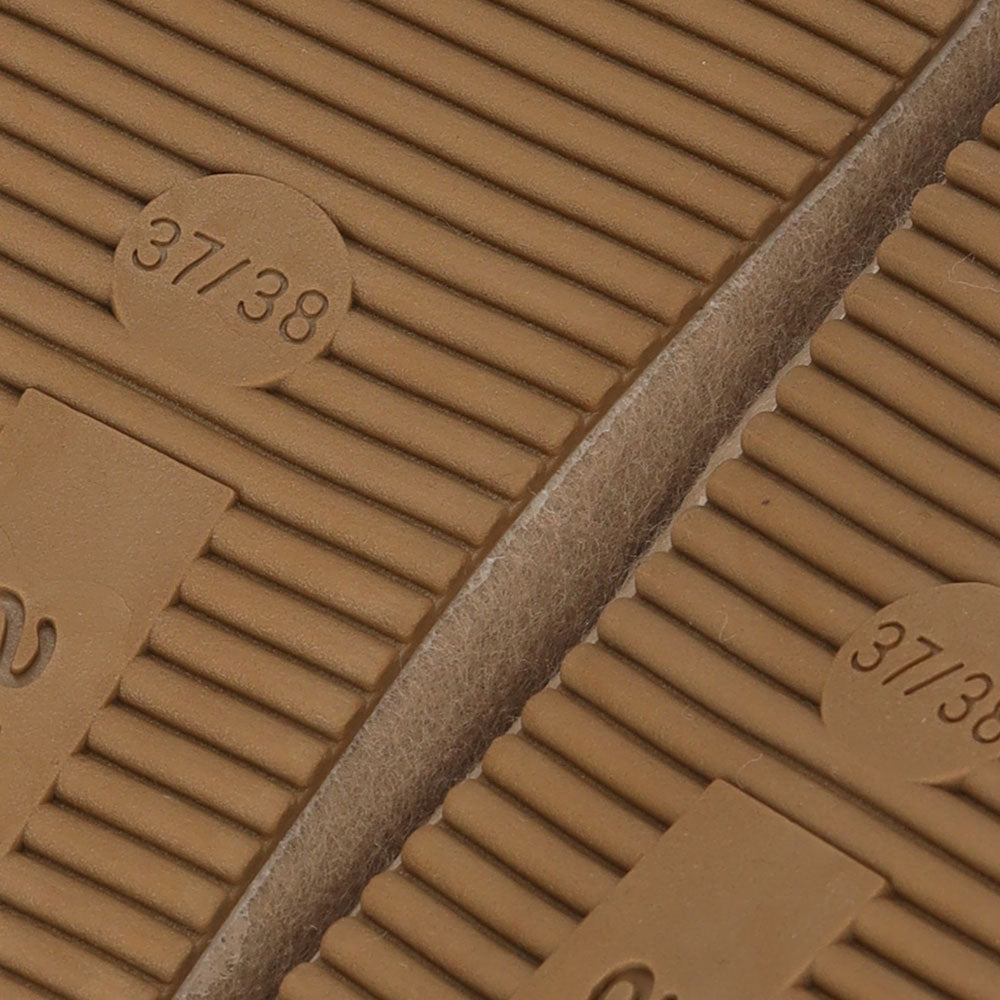 Close-up van de antislip rubberen zool van Apollo dames instap sloffen in beige