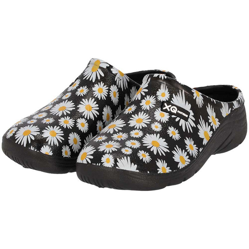 De XQ Tuinklompen Dames met Margrietjesprint zijn lichtgewicht zwarte instapklompen van EVA-kunststof met witte margrieten en gele harten, een iets verhoogde hak en een klein logo aan de zijkant.