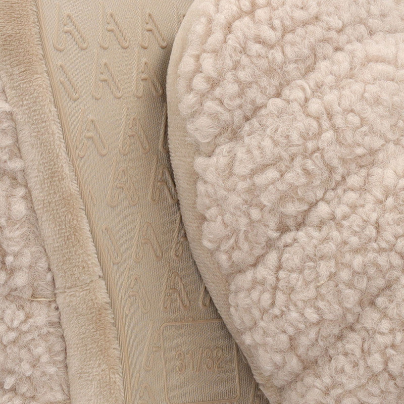 Close-up van het zachte teddy materiaal van Apollo kinderen huissloffen in beige kleur