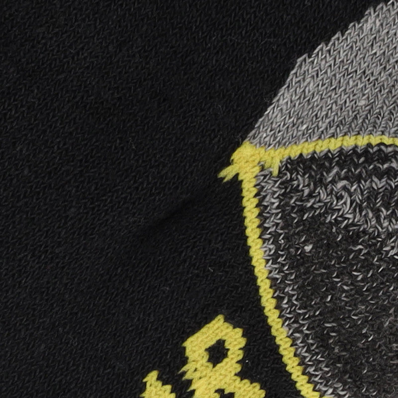 Een close-up van zwarte stof met een gedetailleerd grijs, geel en wit geborduurd patroon, typisch voor Apollo Heren werksokken halfhoog 3-pack voor heren.