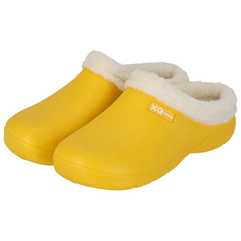 De XQ Tuinklompen Dames Met Bontje Fashion - Geel zijn knalgele tuinklompen voor dames, met een witte fluffy voering, gesloten teen, antislipzool en het XQ-logo op de zijkant.