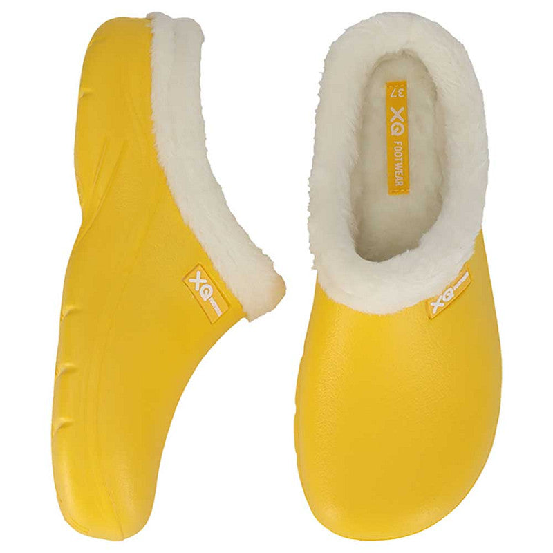 Een paar XQ Tuinklompen Dames Met Bontje Fashion - Geel met witte fluffy voering, XQ logo op zij-/ binnenzool en antislip zool. Getoond vanaf de zijkant en bovenkant op een witte achtergrond.