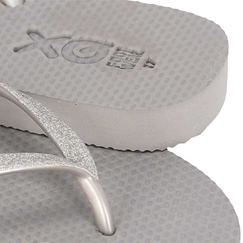 Vrouw draagt XQ dames slippers met grijze glitterbandjes bij het zwembad