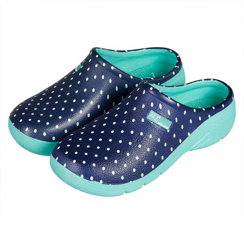 Een paar XQ Tuinklompen Dames - Lichtgewicht & Stippenprint in marineblauw met witte stippen, met een lichtgewicht EVA constructie, lichtblauwe zolen en een binnenvoering.