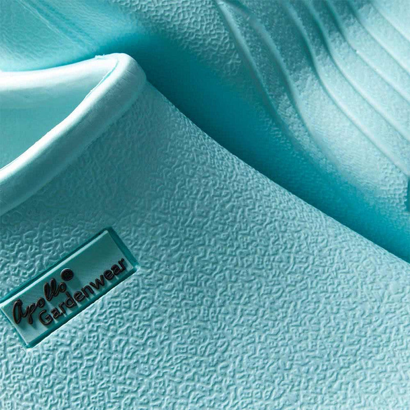 Close-up van XQ Tuinklompen Dames Turquoise - Instapmodel & Lichtgewicht: gestructureerde, lichtblauwe rubberen tuinklompen met een kleine Gardenwear badge. Deze stijlvolle, lichtgewicht klompen bieden comfort en gemak bij het tuinieren.