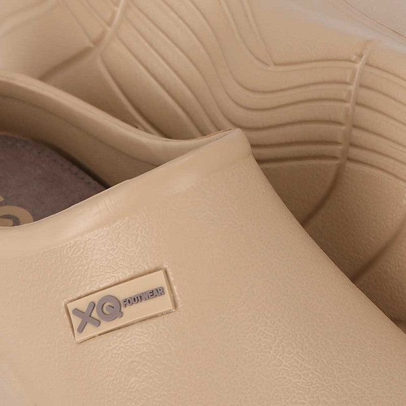 Close-up van XQ Tuinklompen Dames Zand - Instapmodel & Lichtgewicht, met een beige kleur, gestructureerd oppervlak, zichtbaar XQ POWER-label aan de zijkant en golvend zoolpatroon voor een comfortabele en gemakkelijke tuinschoen.