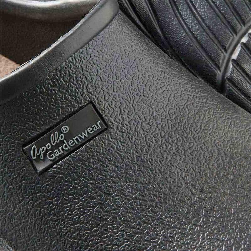 Close-up van een zwarte XQ Tuinklompen Dames Zwart - Instapmodel & Lichtgewicht met structuur, voorzien van een label aan de zijkant - perfect als lichtgewicht slip-on tuinklompen voor dames.