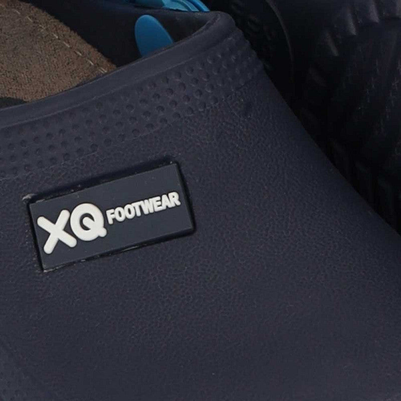 Close-up van een navy XQ Tuinklompen Kinderen slip-on met lichtgewicht EVA en getextureerde afwerking. Het zwart-witte XQ FOOTWEAR-label is zichtbaar, met een ander paar van deze waterafstotende klompen op de achtergrond.