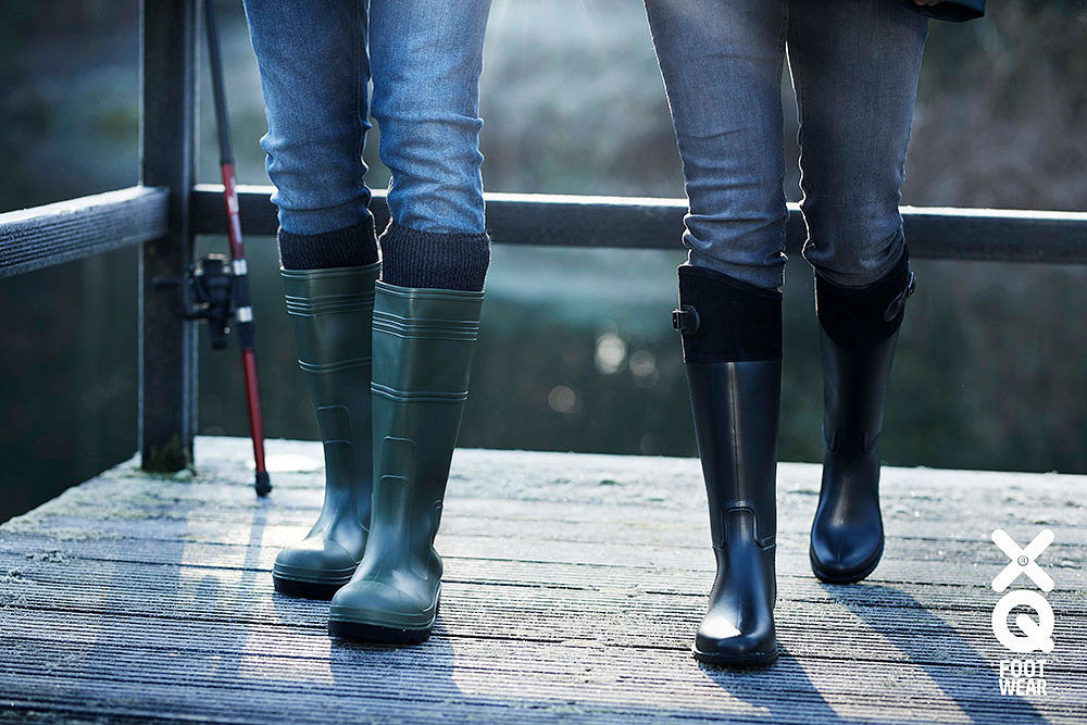Regenlaarzen op een steiger aan het water