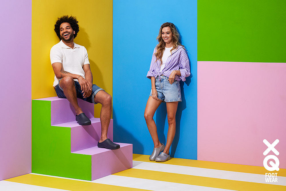 Man en vrouw met XQ-schoenen op kleurige trappen