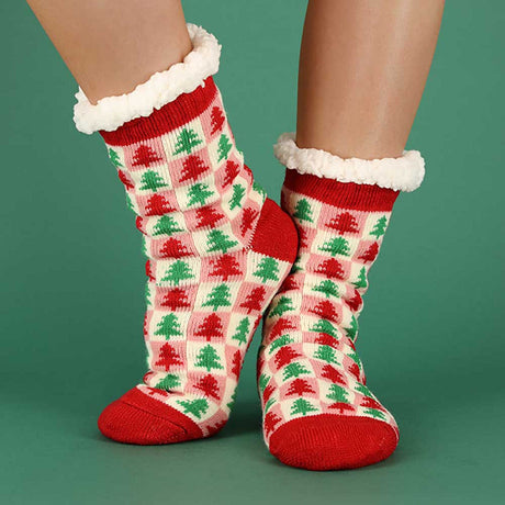 Vrouw draagt rode Apollo x-mas sokken tijdens gezellige kerstdagen thuis bij de open haard