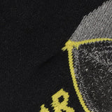 Een close-up van zwarte stof met een gedetailleerd grijs, geel en wit geborduurd patroon, typisch voor Apollo Heren werksokken halfhoog 3-pack voor heren.
