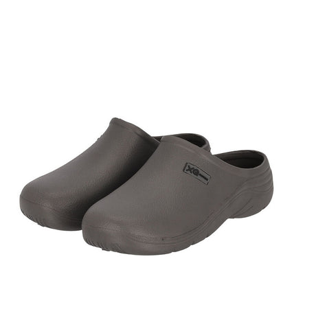De XQ Tuinklompen Heren Grijs - Instapmodel & Lichtgewicht zijn donkergrijze slip-ons met gesloten teen, getextureerde zolen en een logo aan de bovenkant. Dit waterafstotende instapmodel is ideaal voor dagelijks buitengebruik.
