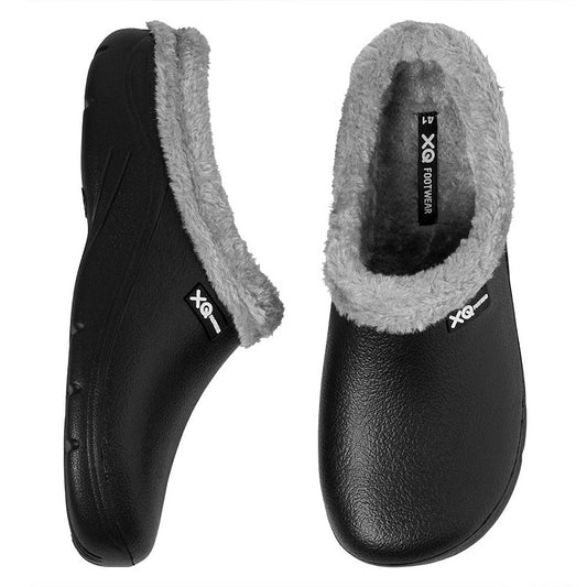 Een paar XQ Tuinklompen Heren Met Bontje Zwart-instapmodel, lichtgewicht tuinklompen met zwart gevoerde buitenkant, grijs faux fur bontje bij de opening, waterafstotend en voorzien van XQ Footwear label. Getoond zij- en bovenaanzicht.