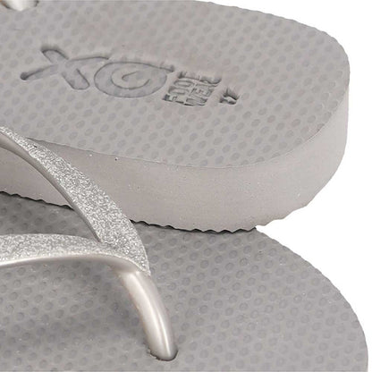 Vrouw draagt XQ dames slippers met grijze glitterbandjes bij het zwembad