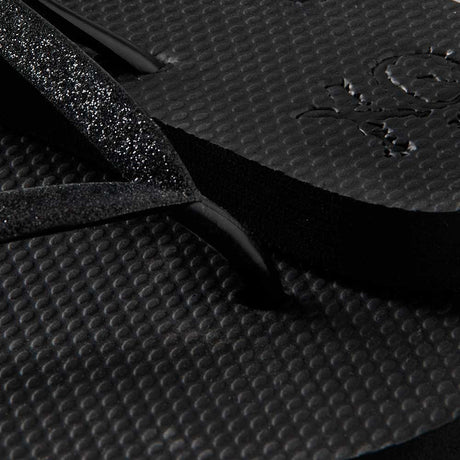 Vrouw draagt XQ dames slippers met zwarte glitterbandjes op een terras