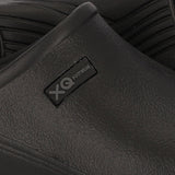 Close-up van de XQ Tuinklompen Heren Zwart - Instapmodel & Lichtgewicht, een zwarte, waterafstotende slip-on van lichtgewicht EVA-kunststof met een XQ FOOTWEAR-label; op de achtergrond staat een andere klomp met een gegroefde zool.