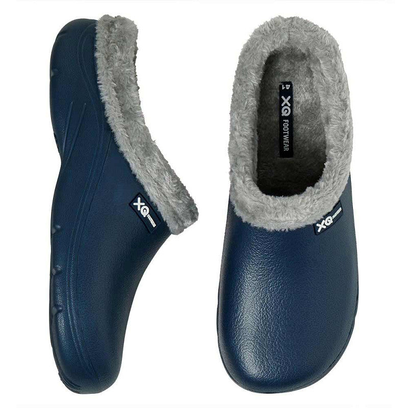 Een paar XQ Tuinklompen Heren Met Bontje Navy, instapmodel & lichtgewicht, met grijze voering van imitatiebont en antislip zool. Afgebeeld van boven- en zijaanzicht, met een klein "XO" label aan de zijkanten.